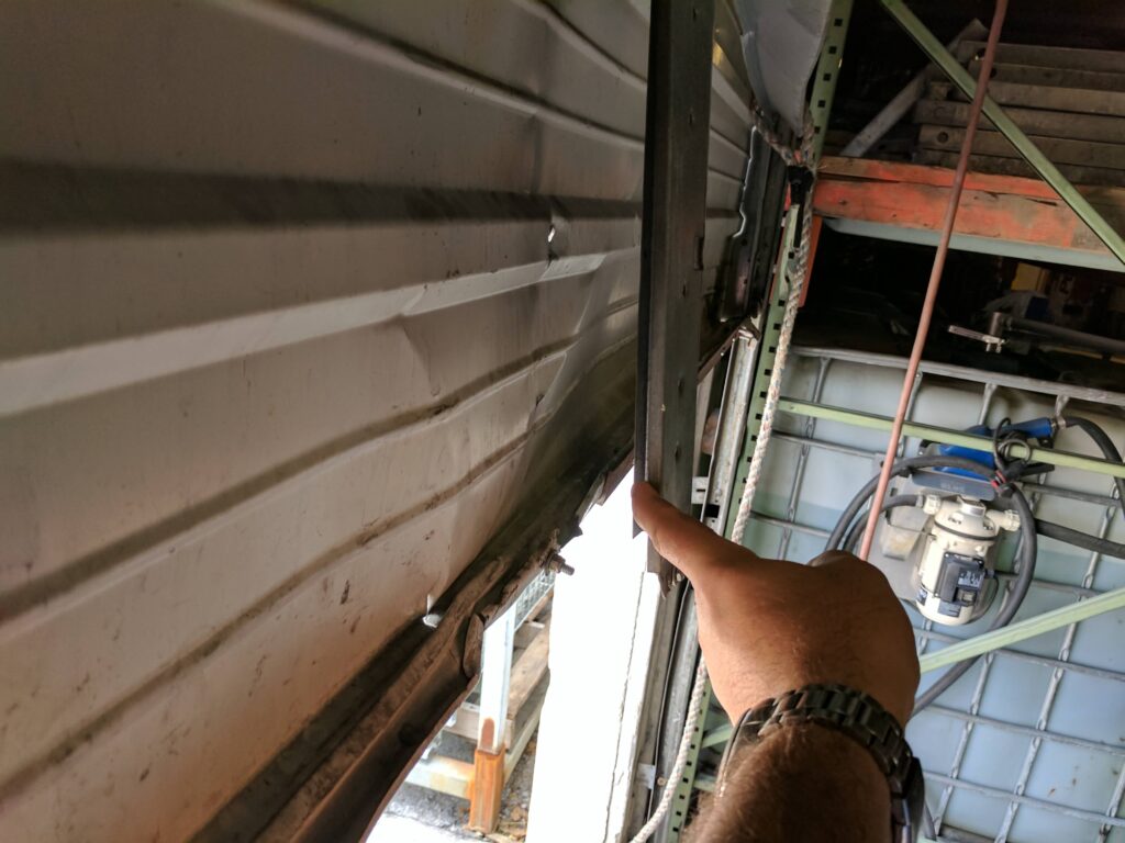 Garage door repair technician working on a broken spring in Pinecrest, FL